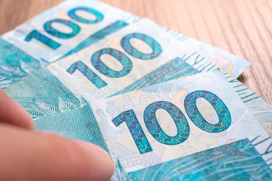 man-with-hundred-reais-bills-brazilian-real-that-are-wooden-furniture Fotografia: Freepik
