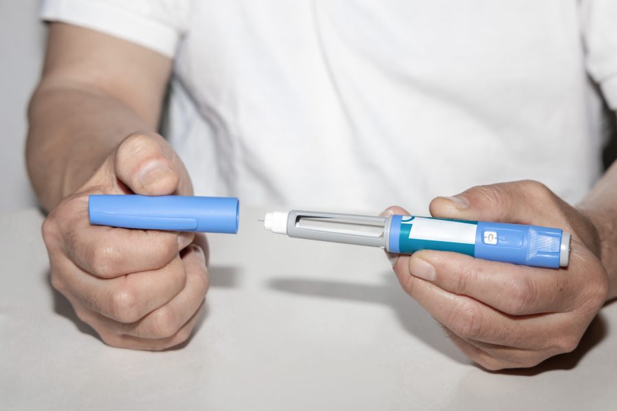 Ozempic Insulin injection pen or insulin cartridge pen for diabetics. Man holding an injection pen for diabetic. Medical equipment for diabetes parients.