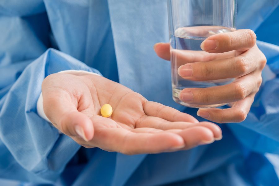 Woman's hand pours the medicine pills out of the bottle